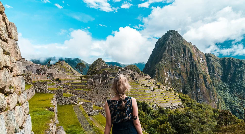 Traveler looking out over the Machu Picchu citadel and Huayna Picchu