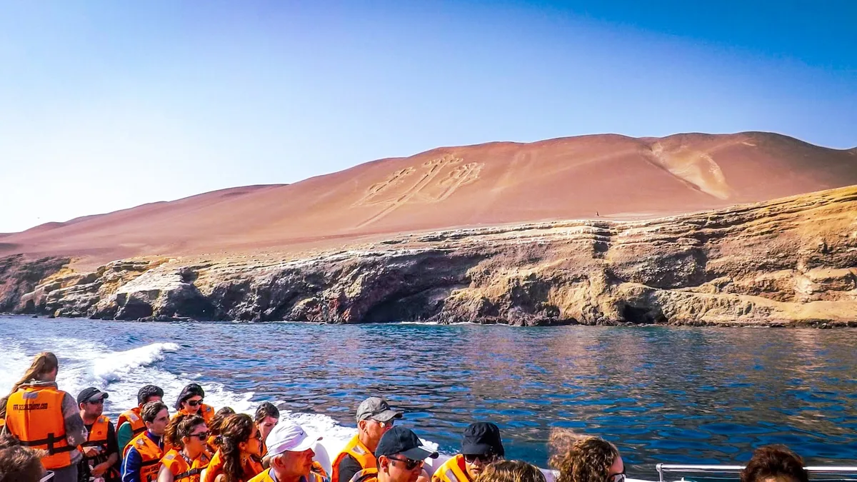 A tour boat carrying travelers across the water by the Ballestas Islands near Paracas, Peru