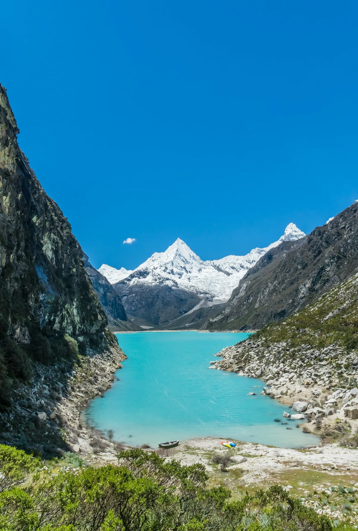 Turquoise glacial lake below the snow peaks of the Cordillera Blanca